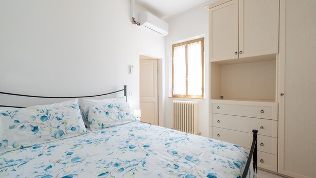 A bedroom with a bed, a wardrobe, a radiator, and a window. - Casa Roda – Your Home by Lake Trasimeno, Between Umbria and Tuscany (Castiglione del Lago)