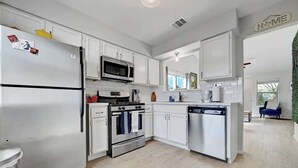 A modern kitchen with white cabinetry, stainless steel appliances, and a dishwasher. - South Austin Retreat: Pet-Friendly Townhouse (Austin)