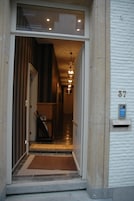A hotel entrance with a reception desk, a mail slot, and a number 37 sign on the wall.