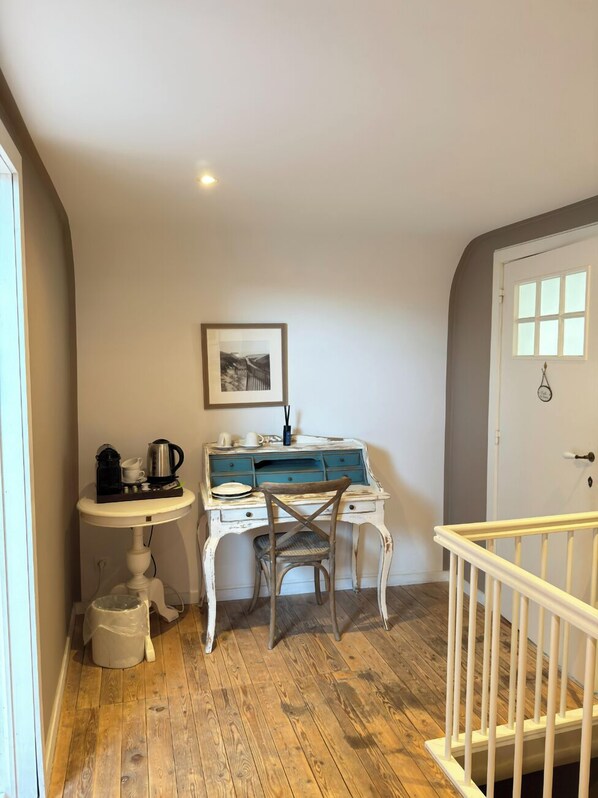 A small, cozy room with a white desk, a chair, a small sink, and a wooden floor. - La Luna guesthouse (Bruges)