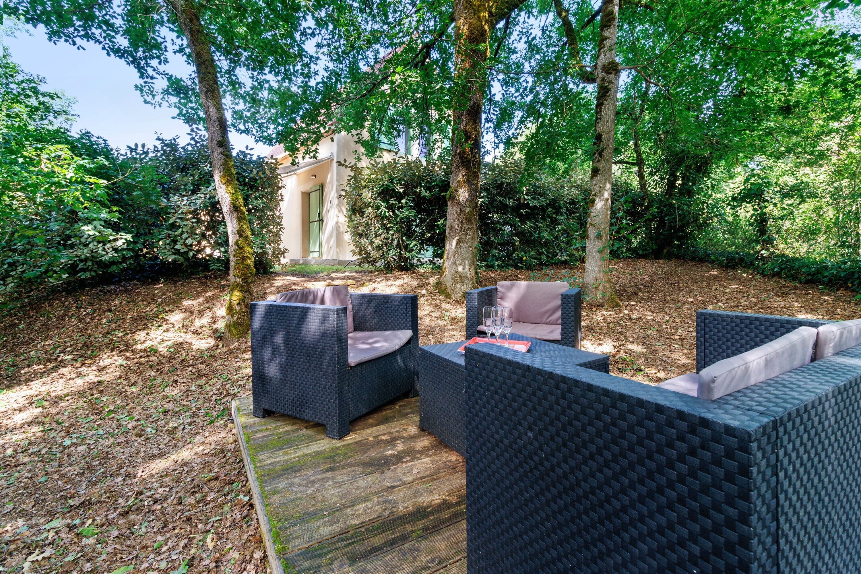 An outdoor seating area with wicker furniture and a wooden deck.