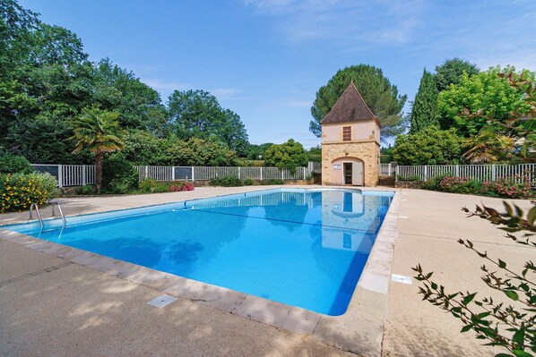 A swimming pool with a stone building in the background. - Charming Maisonnette near Sarlat-la-Canéda with Shared Pool, Private Terrace & Garden (Carsac-Aillac)