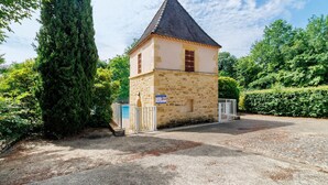 Un bâtiment en pierre doté d’un toit conique, d’une entrée fermée par un portail et d’un panneau indiquant qu’il s’agit d’une propriété privée.