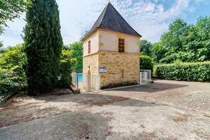 A stone building with a conical roof, a gated entrance, and a sign indicating a private property. - Charming Maisonnette near Sarlat-la-Canéda with Shared Pool, Private Terrace & Garden (Carsac-Aillac)