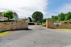 A gated entrance to a property named 'Carsac' with stone walls and a clear sky. - Charming Maisonnette near Sarlat-la-Canéda with Shared Pool, Private Terrace & Garden (Carsac-Aillac)