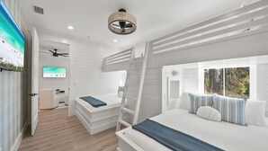 A modern bedroom with a bunk bed, a desk, and a TV.