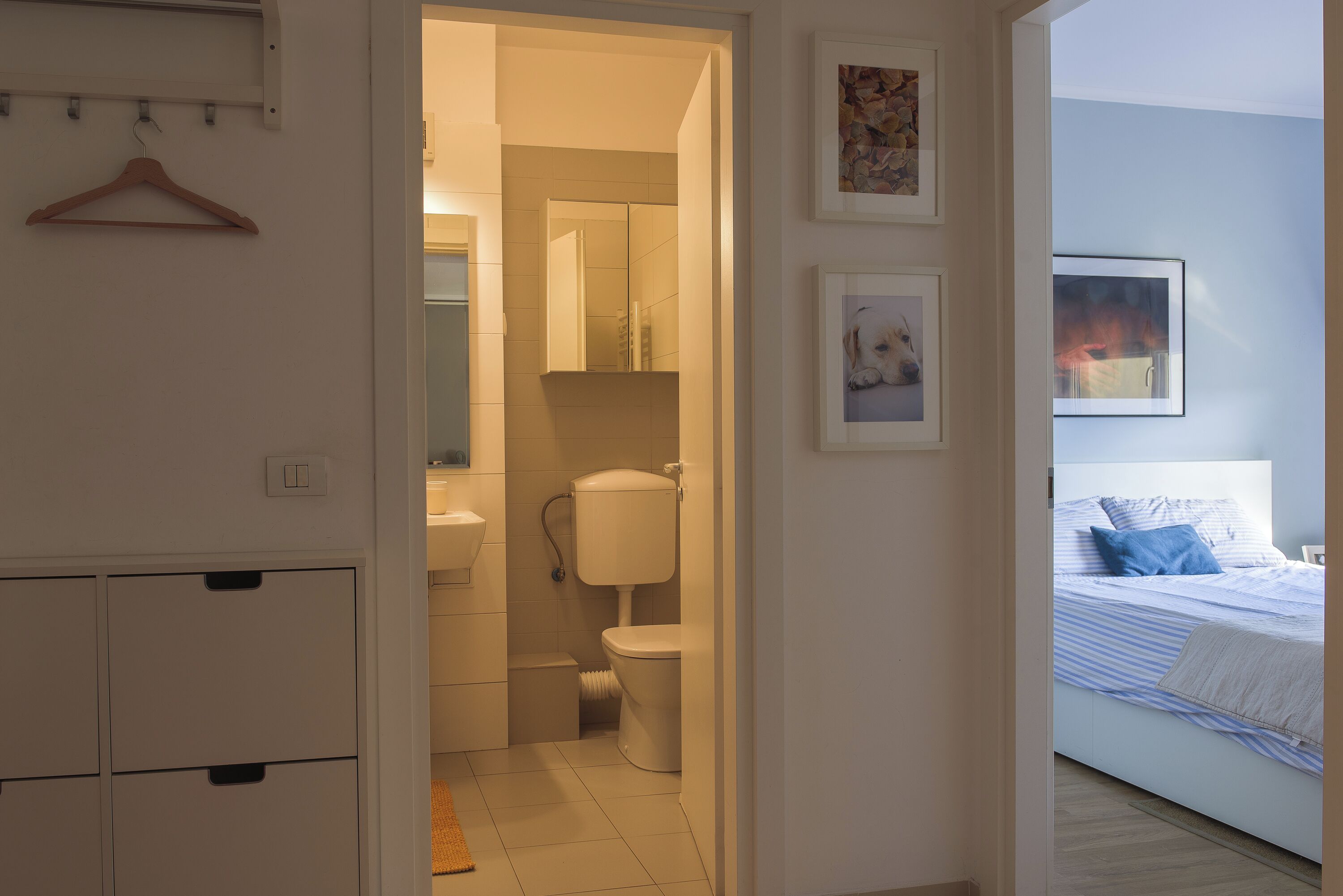 A bedroom with a bed, a bedside table, and a wall-mounted TV.