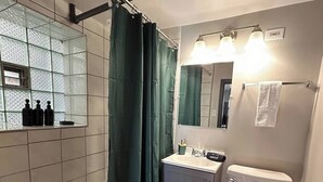 Kylpyhuone, jossa on kylpyamme, wc, pesuallas ja peili.