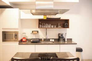 Refrigerador, microondas, utensilios de cocina, mesa de comedor