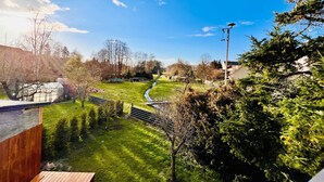 Un barrio residencial con césped, un sendero y una terraza de madera.