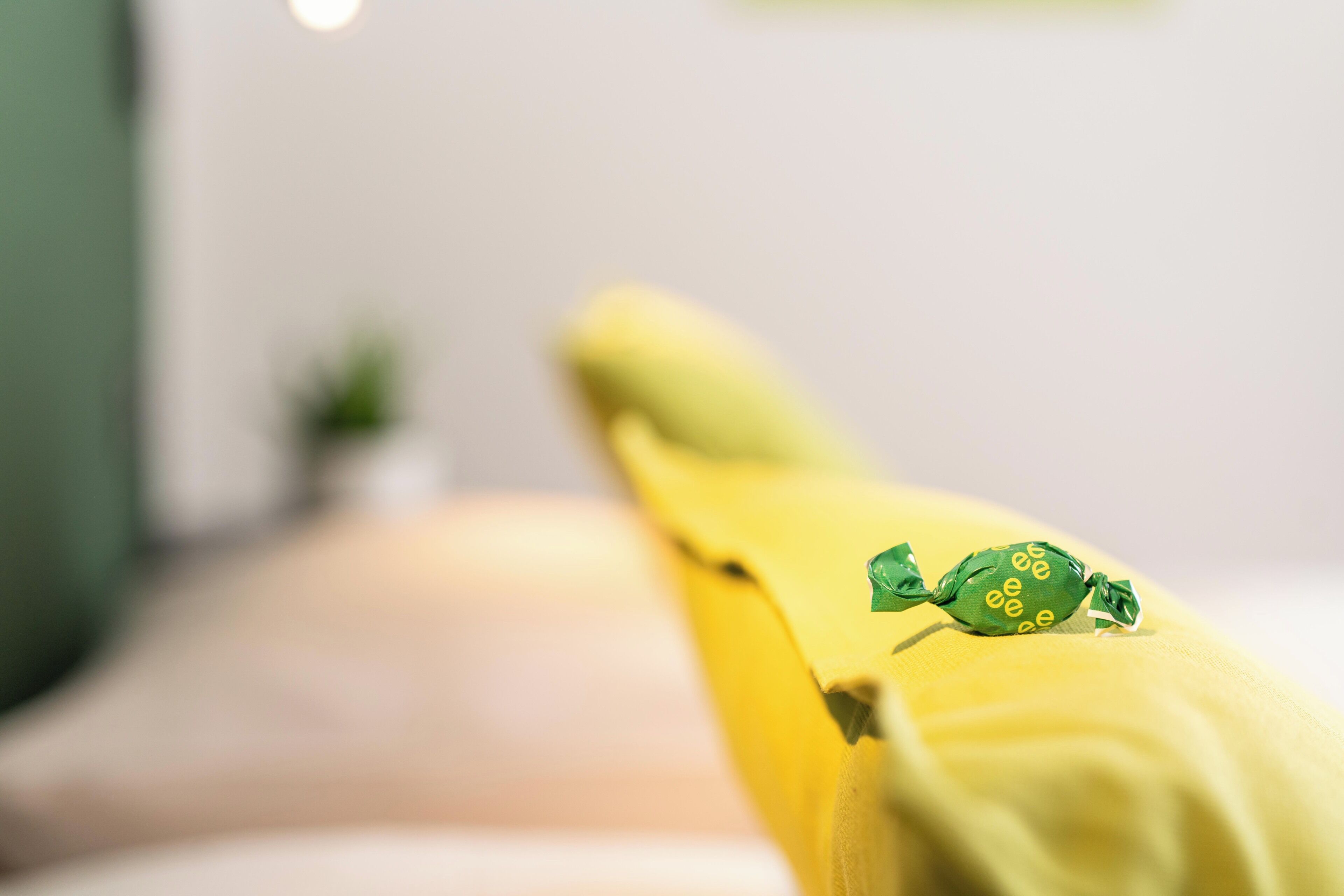 A close-up of a yellow fabric with a green object on it.