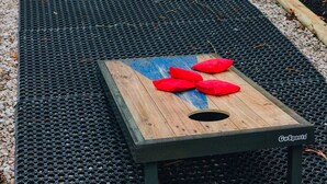 Une terrasse en bois avec une table et un banc, entourée d’un sol en treillis métallique.