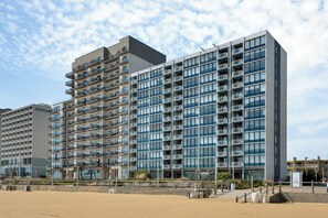 Un hôtel à plusieurs étages doté de balcons, offrant une vue sur la plage et présentant une architecture moderne.