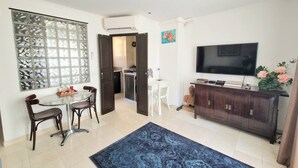 A modern living room with a TV, dark wooden cabinet, and a blue rug. - Paris TROCADERO, 5 mn from the TOUR EIFFEL apartment for 4 people (Paris)
