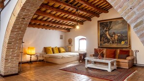 A cozy room with a bed, a sofa, a coffee table, and a painting on the wall. - Masia Notari Casabona (Vilanova I la Geltru)