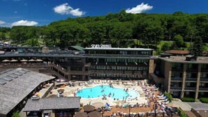 Un hôtel doté d’une piscine, d’un espace extérieur aménagé et offrant une vue sur la forêt environnante.