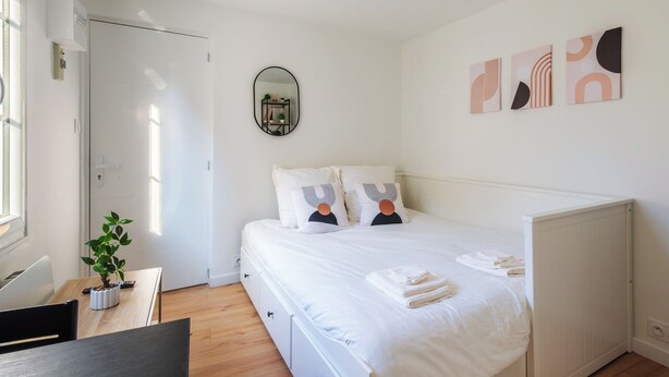 A bedroom with a bed, bedside tables, a potted plant, and artwork on the wall. - L'Ambroise - Wifi - Centre-ville - Gare (Laval)