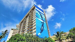Ein hohes Hotel mit einem auffälligen, blau-weißen Wandgemälde eines Pinguins an der Seite.