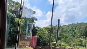 Une pièce dotée d’une grande fenêtre en verre donnant sur une rivière et la verdure environnante.
