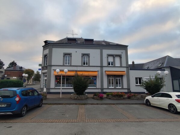 Un edificio de dos pisos con un restaurante en la planta baja, que presenta un diseño moderno con grandes ventanales y techo plano.