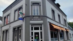 A two-story building with a sign reading "HOTEL de la PLAGE".