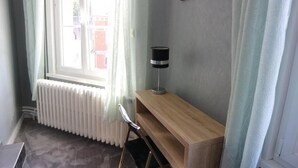 A room with a radiator, a wooden desk, and a lamp.