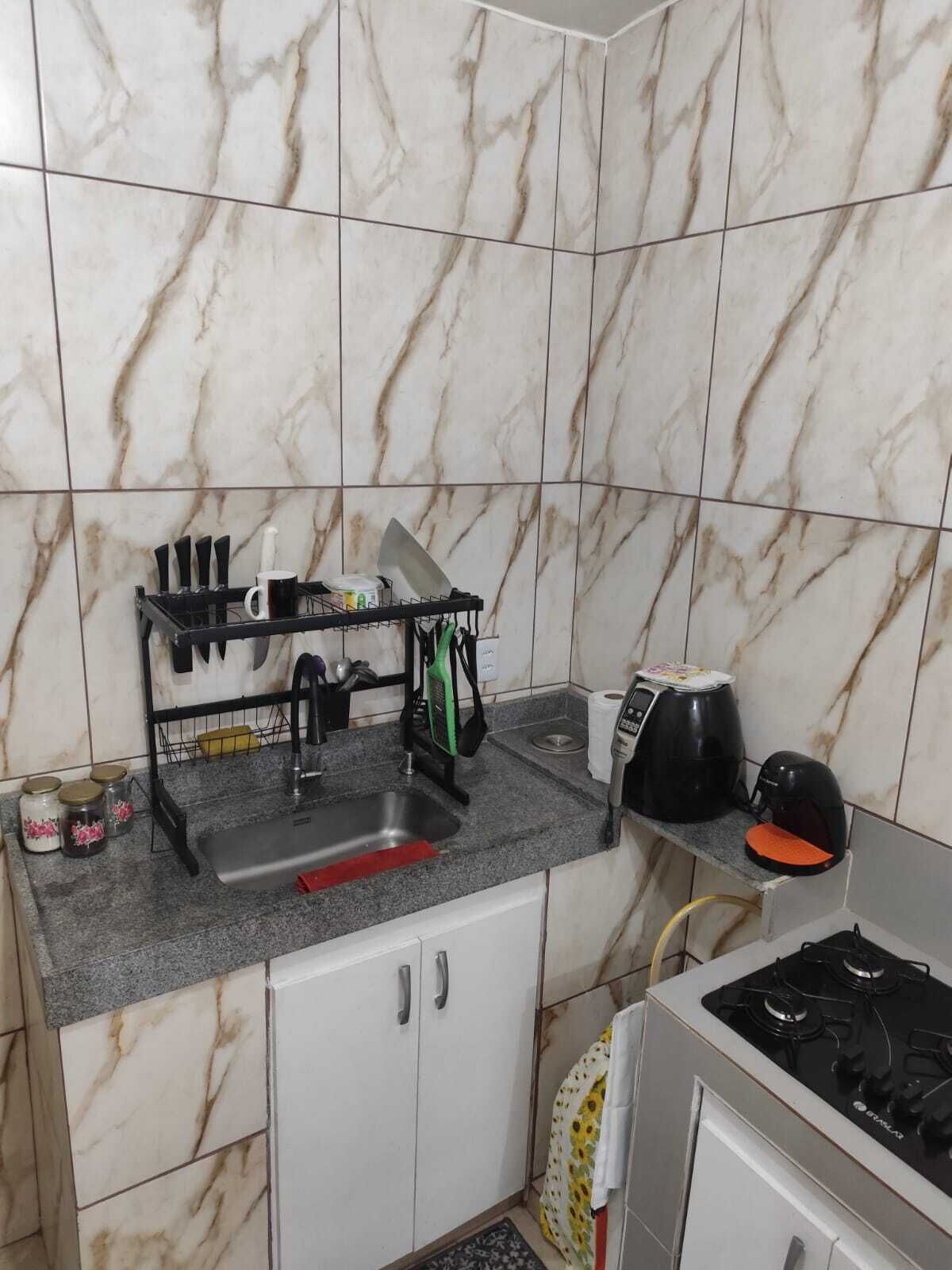 A compact kitchen with a sink, countertop, and stove.