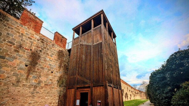 A rustic wooden building with a sloped roof, a brick wall to the left, and a paved pathway leading to it. - Charming retreat with terrace over Pisa's hidden gardens (Pisa)
