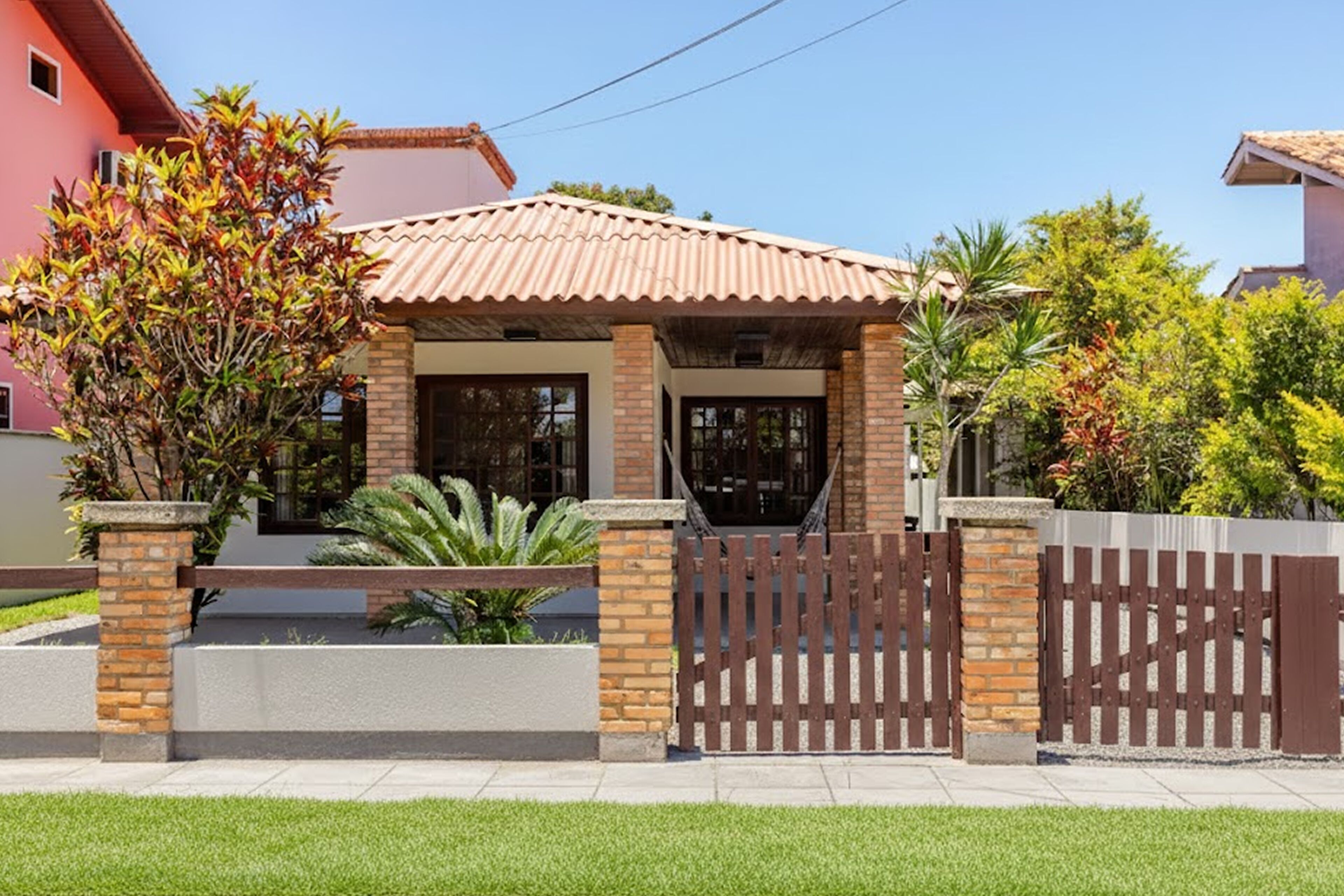 A house with a tiled roof, brick walls, and a wooden gate.