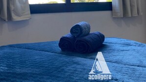 Una habitación con cama, ventana con cortinas y vista a árboles y la luna.