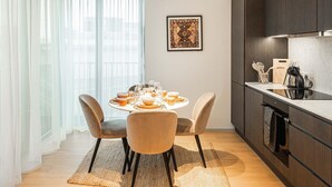 Una cucina moderna con mobili in legno scuro, un piano di lavoro bianco e un forno integrato.