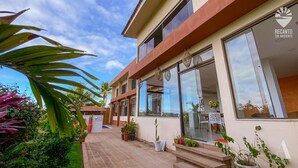 A modern building with large windows, a patio area with potted plants, and a sign reading "RECANTO SOL NASCENTE". - Pousada Recanto Sol Nascente (Rio Formoso)