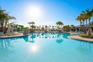 A swimming pool with clear water, surrounded by palm trees and lounge chairs. - 7BR Windsor Cay w/ Game Room & Pool Near Disney (Clermont)
