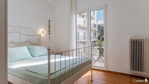 Un dormitorio con cama, balcón y radiador.