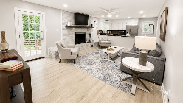 A modern living room with a fireplace, a sofa, a coffee table, and a TV.