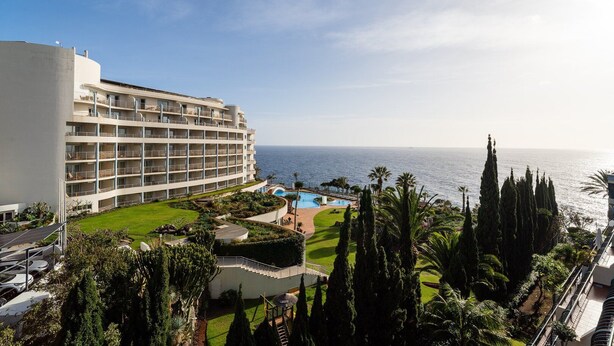 A hotel with multiple floors, a pool area, and a view of the sea. - GuestReady - Seaside Retreat (Funchal)