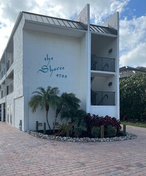 Ein Gebäude mit einem Schild, auf dem "The Shores 4750" steht, und einem eingenetzten Eingang.