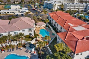 A resort with multiple buildings, a central swimming pool, and a tennis court. - New! Summer Deal: Free Fun and Beach Gear Credit (St. Augustine)