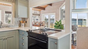 Una cocina moderna con una isla grande, detalles de madera y vistas al exterior.
