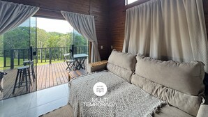 Un interior de fusta amb un balcó, un sofà i una manta estampada.