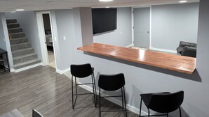 Une cuisine moderne avec un plan de travail en bois et deux tabourets de bar noirs.