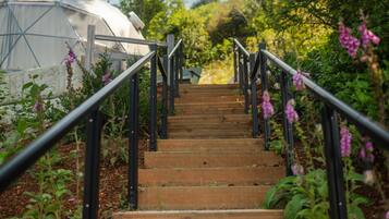 A wooden staircase with black railings leading to a covered structure.
