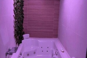 A bathroom with a white bathtub, a plant, and a wooden wall. - Amazon Jacuzzi Relax in the Heart of the Harbor (El Puerto de Santa María)