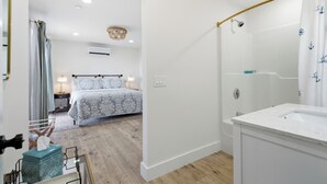Een moderne badkamer met een douche, een wastafel en een spiegel.