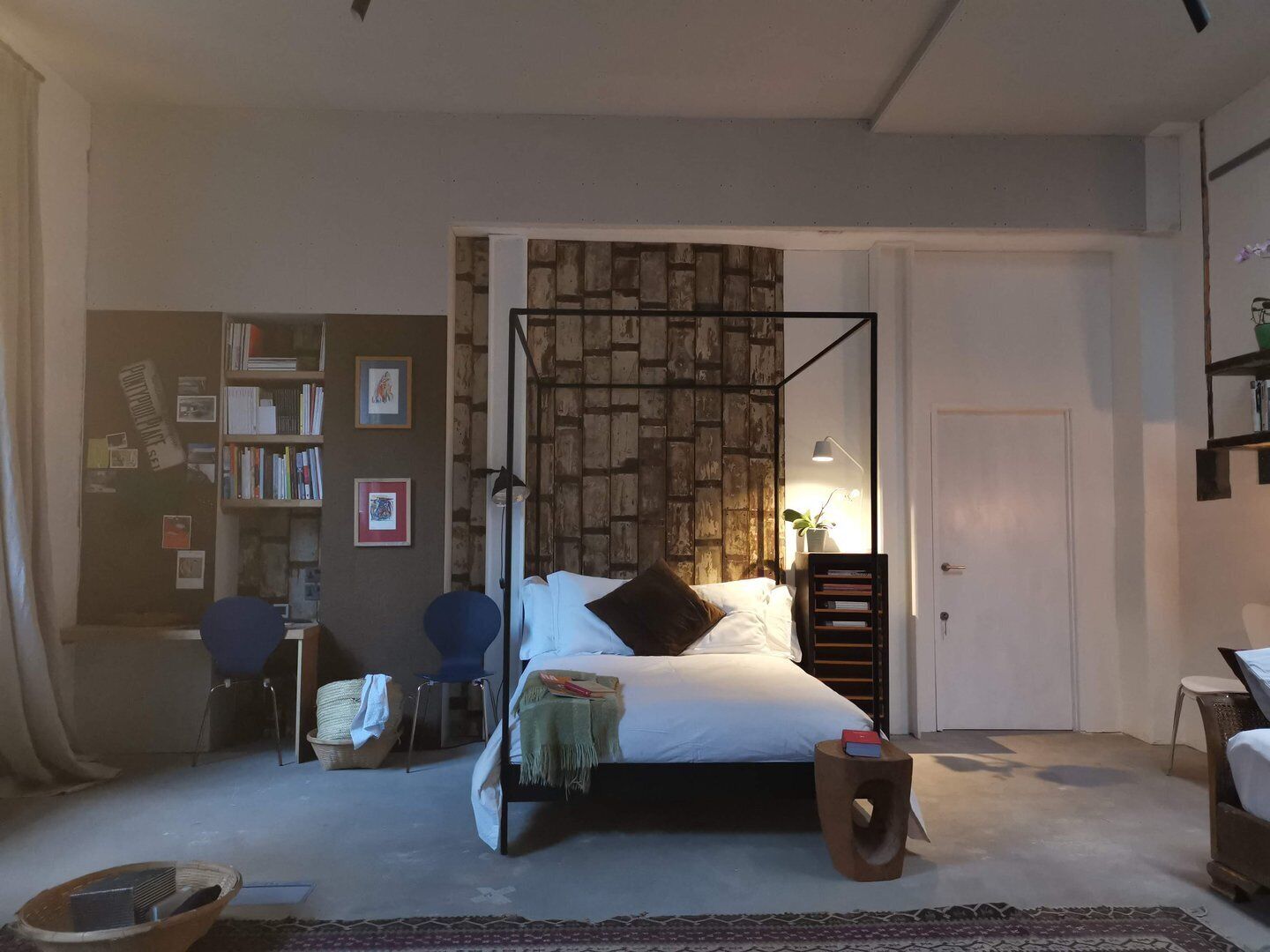 Une chambre à coucher avec un lit à baldaquin, une bibliothèque, un bureau et une chaise.