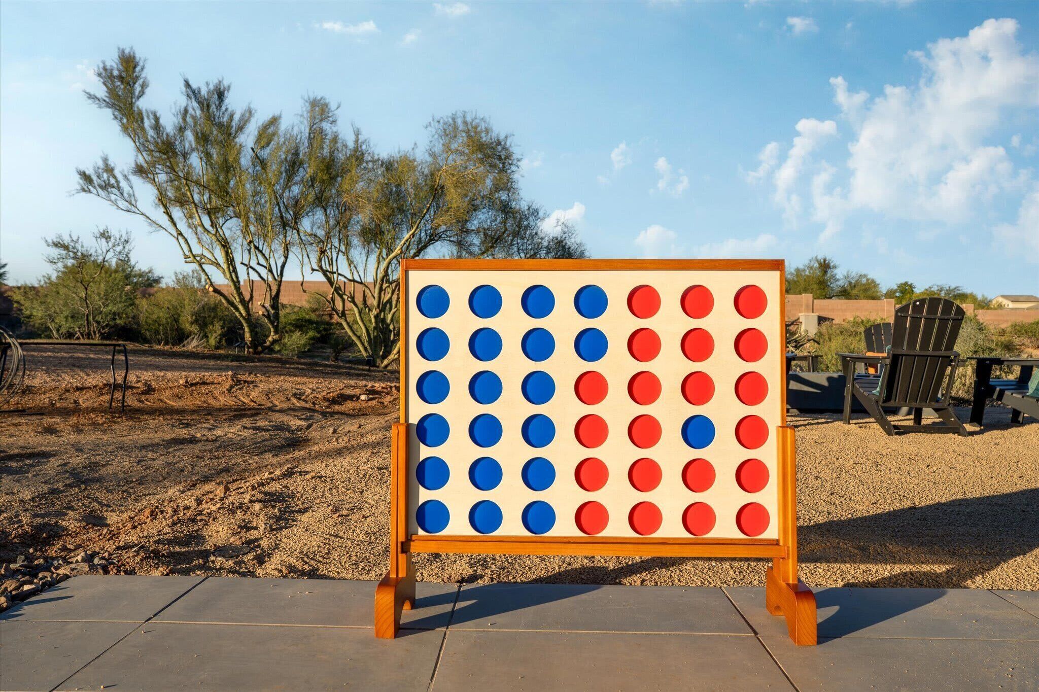 A board game setup outdoors with a clear sky and trees in the background.