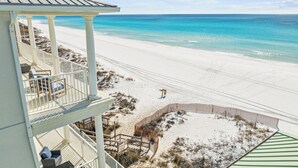 En fastighet som ligger vid stranden och har en balkong med utsikt över havet.