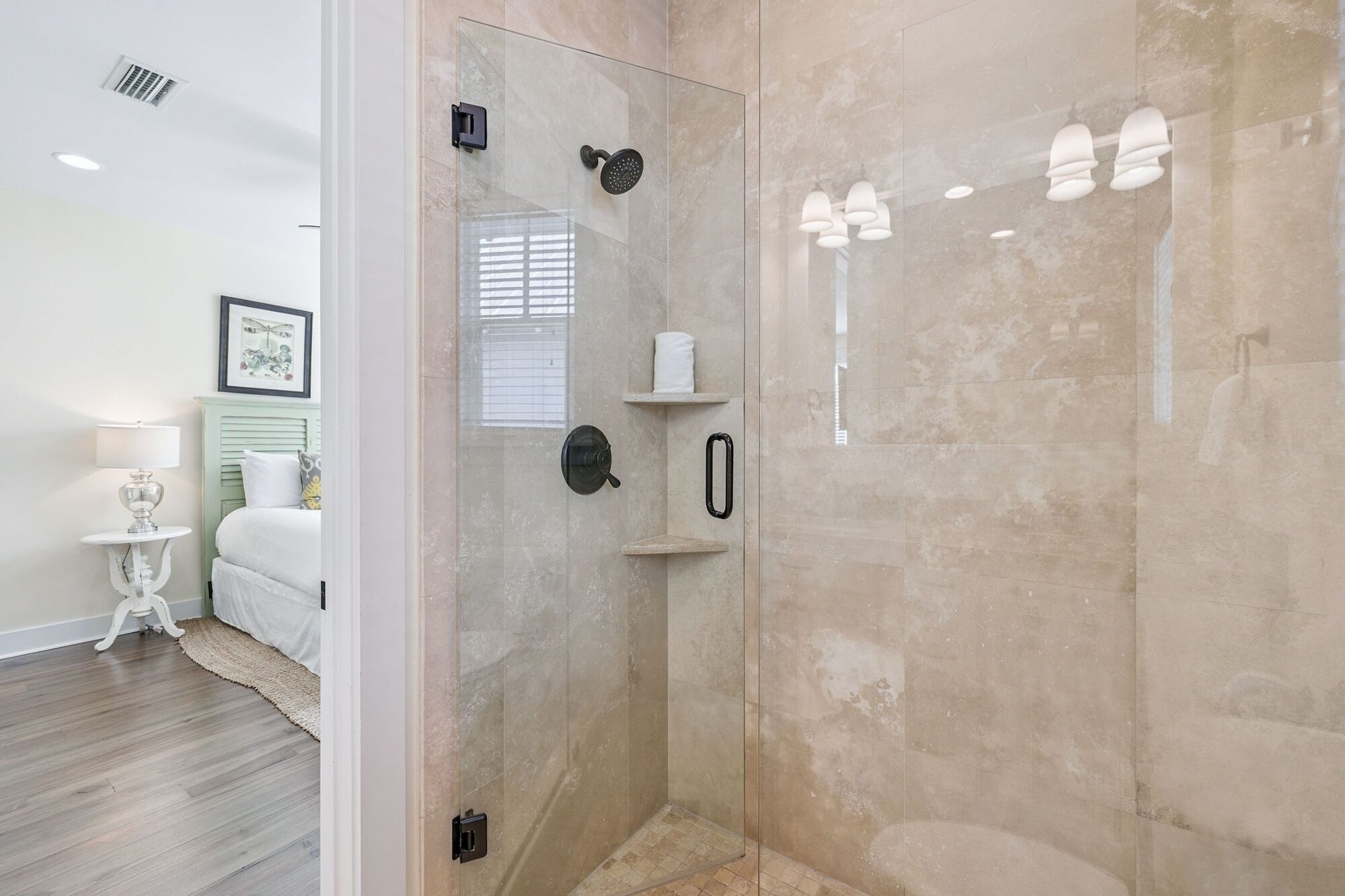 A modern bathroom with a glass-enclosed shower, a toilet paper holder, and a towel rack.