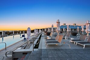 A rooftop pool area with lounge chairs and umbrellas, a pool, and a clear sky. - Watercolor House Steps from Dragonfly Pool (Santa Rosa Beach)