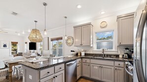 A modern kitchen with grey cabinets, stainless steel appliances, and a granite countertop. - Pool Access | LSV | Dogs Welcome (Santa Rosa Beach)